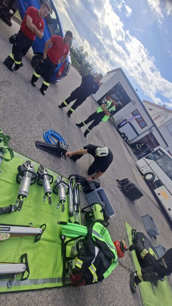 Rettungsgeräte der Feuerwehr mit Einsatzkräften vor einem Feuerwehrhaus in Österreich