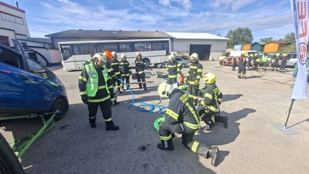 Feuerwehrübung in Österreich: Einsatzkräfte mit Ausrüstung bei einer Übung mit einem verunfallten Auto.